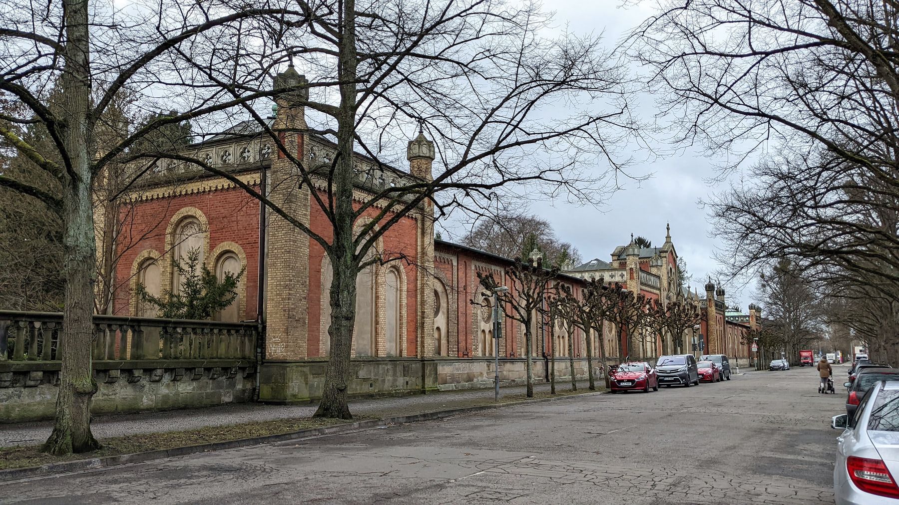 Long side view of the historic brick complex beneath winter trees at Engesohde City Cemetery